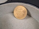 une pièce d'or posée dans une boîte sur une table