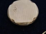 a close up of a gold pocket watch with a chain around it