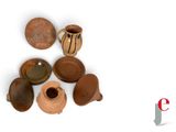many different types of pottery on display on a white surface