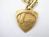 an image of a gold plated necklace with a picture of a horse and rider