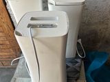 trois toilettes blanches posées sur une caisse en bois