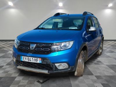 the front end of a blue dacia parked on a checkered floor