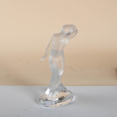 sculpture of a woman standing on a base on a table