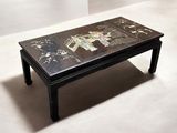 une table basse noire sur laquelle est peint un éléphant