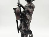 statue of a man holding a guitar and a guitar case