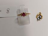 two rings and a ring on a display stand on a white surface