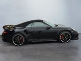 the black porsche 911 gts is parked on the concrete floor