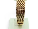 an image of a gold bracelet on a stand on a white surface