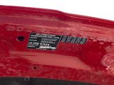a close up of a red car with a sticker on it