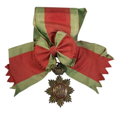 une image représentant un ruban rouge et vert sur lequel est accrochée une médaille en or