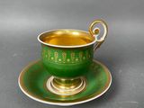 a green cup and saucer on a saucer