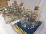 many glass jars on a table with a book on it