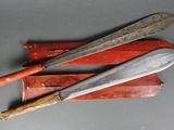 Deux couteaux et un étui à couteau sont posés sur une table