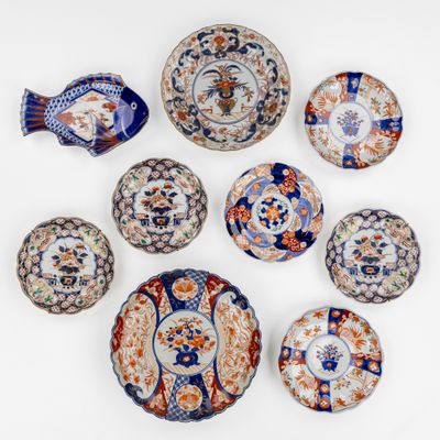 Plusieurs assiettes et bols sont disposés en cercle sur une surface blanche.