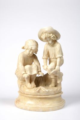 ivory figurine of a boy and a girl washing a dog