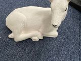 un petit animal blanc assis par terre