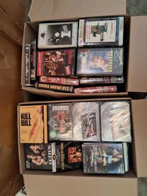 un grand nombre de dvd dans une boîte posée sur le sol