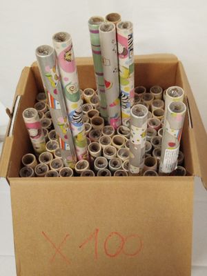 de nombreux rouleaux de papier dans une boîte en carton posée par terre