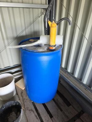 un bidon bleu contenant une pompe jaune