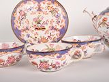 a tea set with a teapot, cups, and saucer