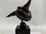 bronze sculpture of a bird on a black base on a white background