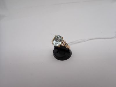 Gros plan sur une bague en or ornée d'une topaze bleue