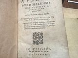 un vieux livre posé sur une table, à côté d'une vitrine