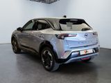 the rear of a silver car in a showroom with a black floor