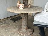 une petite table sur laquelle se trouve un vase, sur la terrasse