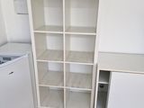 une petite cuisine avec un réfrigérateur blanc et une bibliothèque blanche