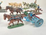 many figurines of horses pulling a carriage with a man on it