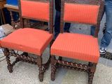 two men standing next to a set of four chairs