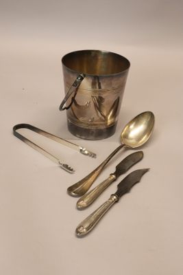 a silver cup with spoons and spoons next to it