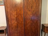 a wooden armoire in a room with a rug on the floor