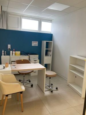 une pièce équipée d'un bureau, d'une chaise, d'étagères et d'un réfrigérateur