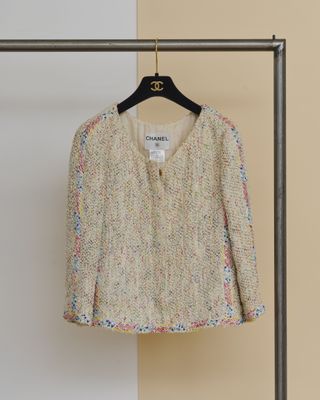 Le pull est suspendu à un cintre devant un mur.