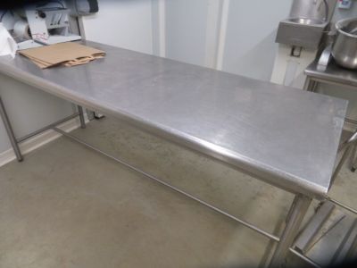 a stainless steel table in the kitchen with a bag on it