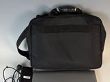 dell laptop with charger and bag sitting on a white table