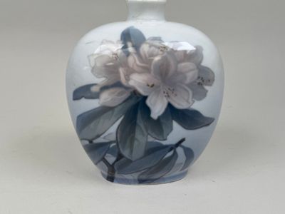 un vase blanc orné d'une fleur bleue et blanche