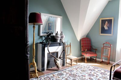 une photo d'une chambre avec une cheminée et un fauteuil