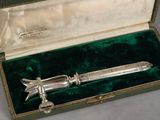 a silver knife in a green box on a table
