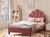 a bed with a pink headboard in the middle of a room