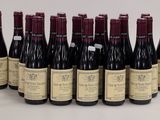 six bottles of wine are lined up in a row on a white surface