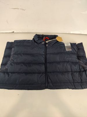 un gros plan d'une veste posée sur une table, avec une étiquette dessus