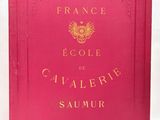 a red book with gold lettering on it sitting on a white surface