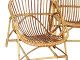 two chairs made of bamboo and wicker are sitting next to each other