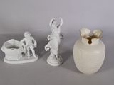 trois figurines assises côte à côte sur une table