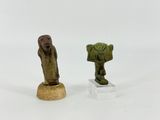two small figurines of a man and a woman on a pedestal