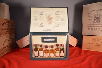 several bottles of alcohol are in a wooden box on a red cloth