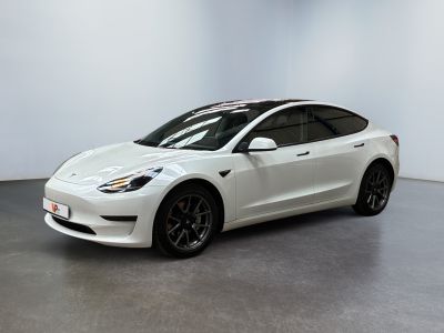a white tesla model 3 parked in a white room